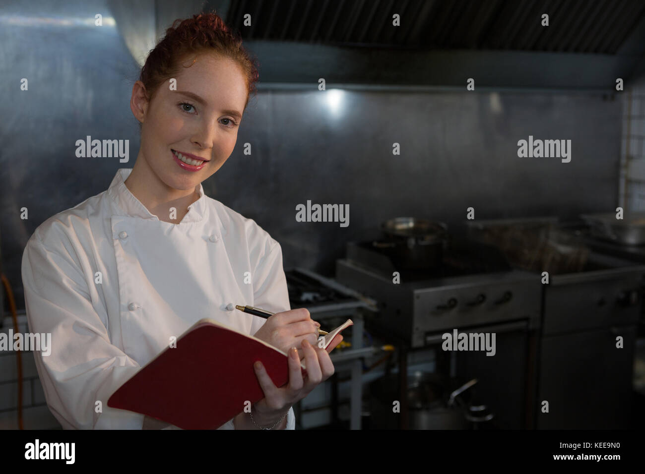 Portrait of female chef taking down an order in the book Stock Photo