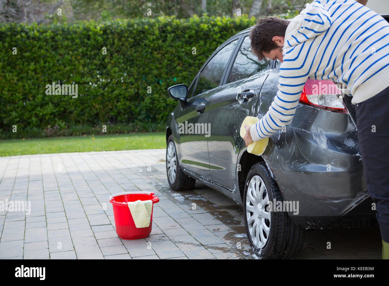 Male auto service staff washing a car with sponge Stock Photo