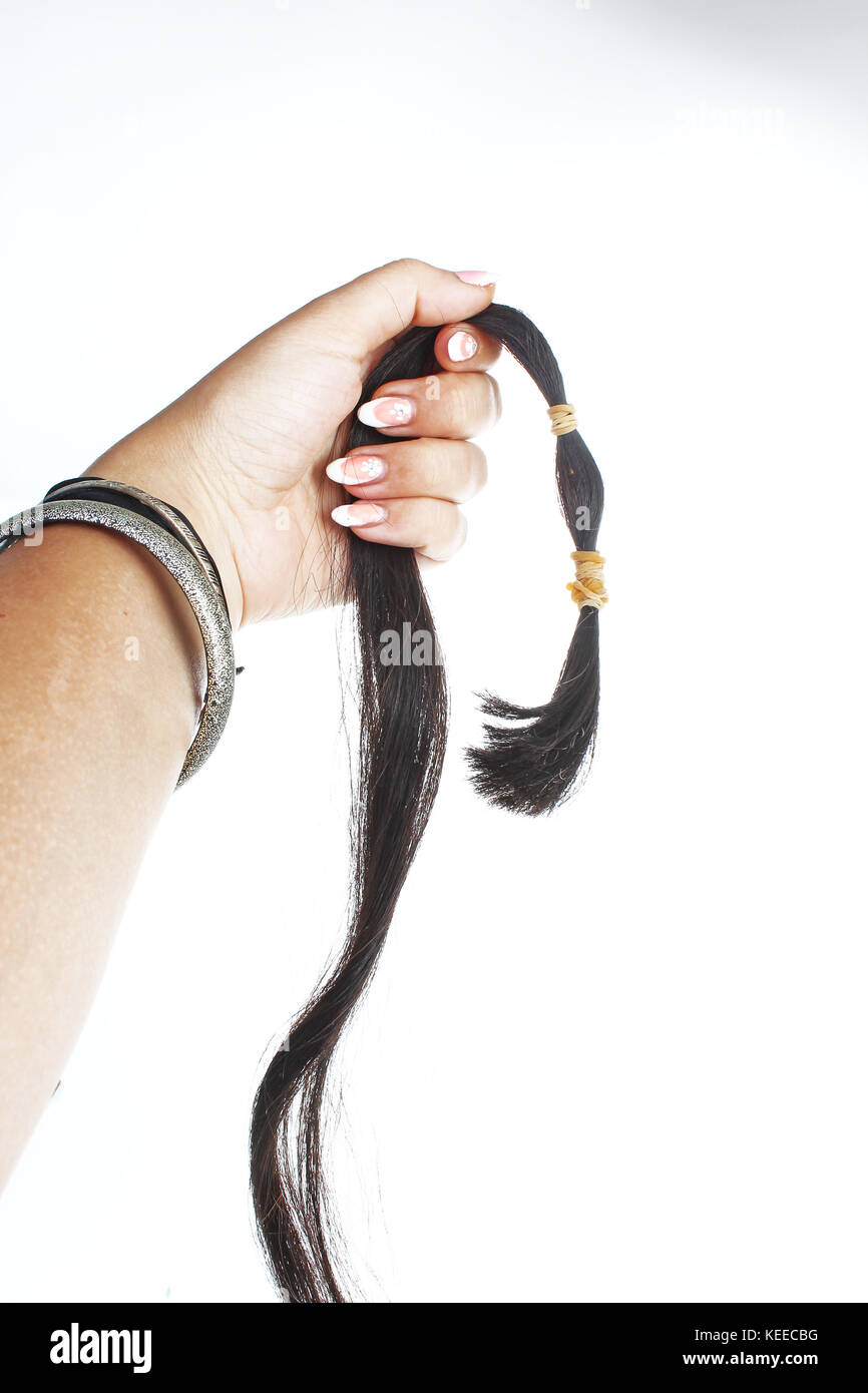 Woman hand holding hair extension tail on isolated white cutout background. Studio photo with studio lighting easy to use for every concept. Stock Photo