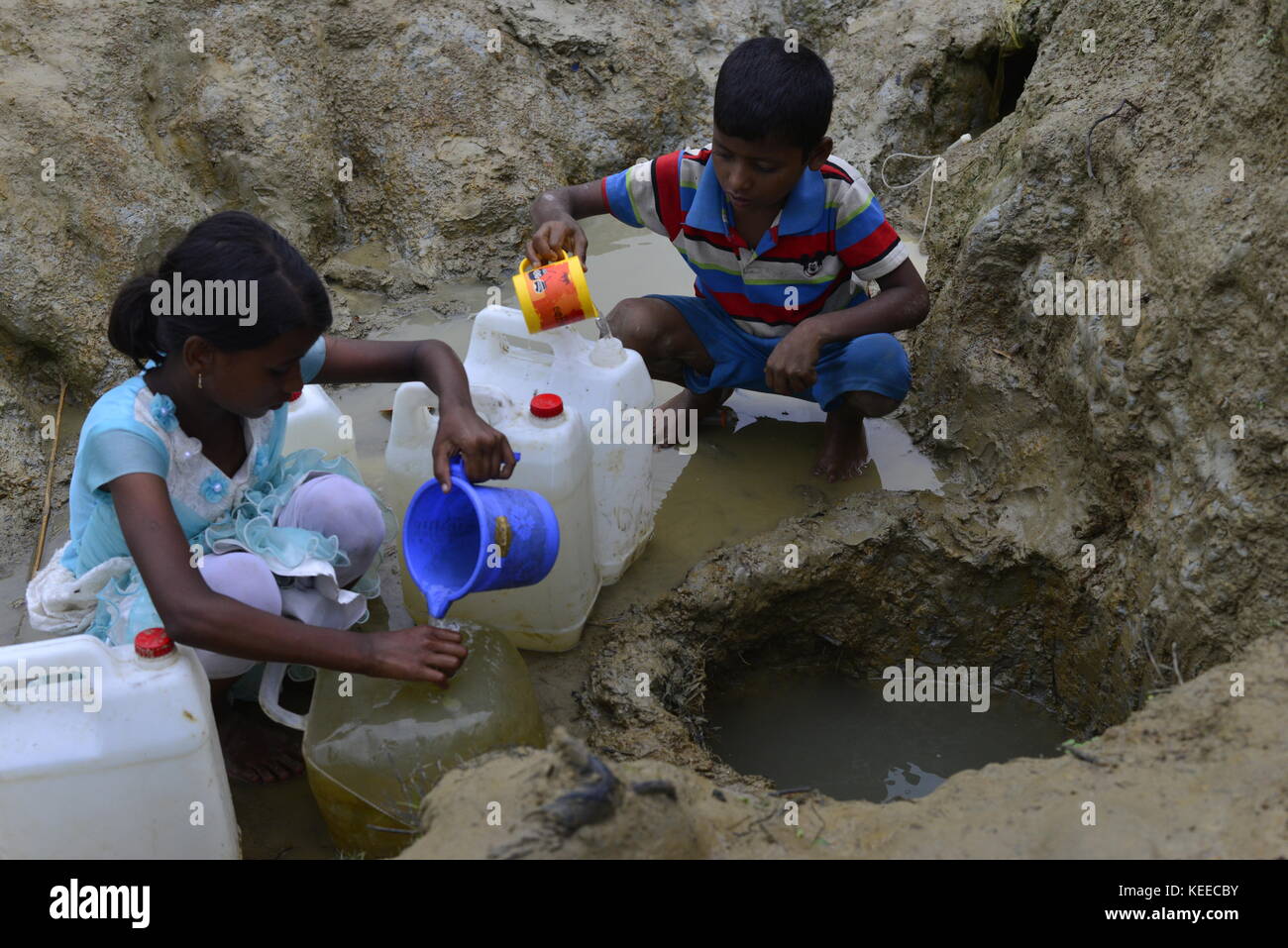 Rohingya children are collects drinking water from the Mud hole at the ...