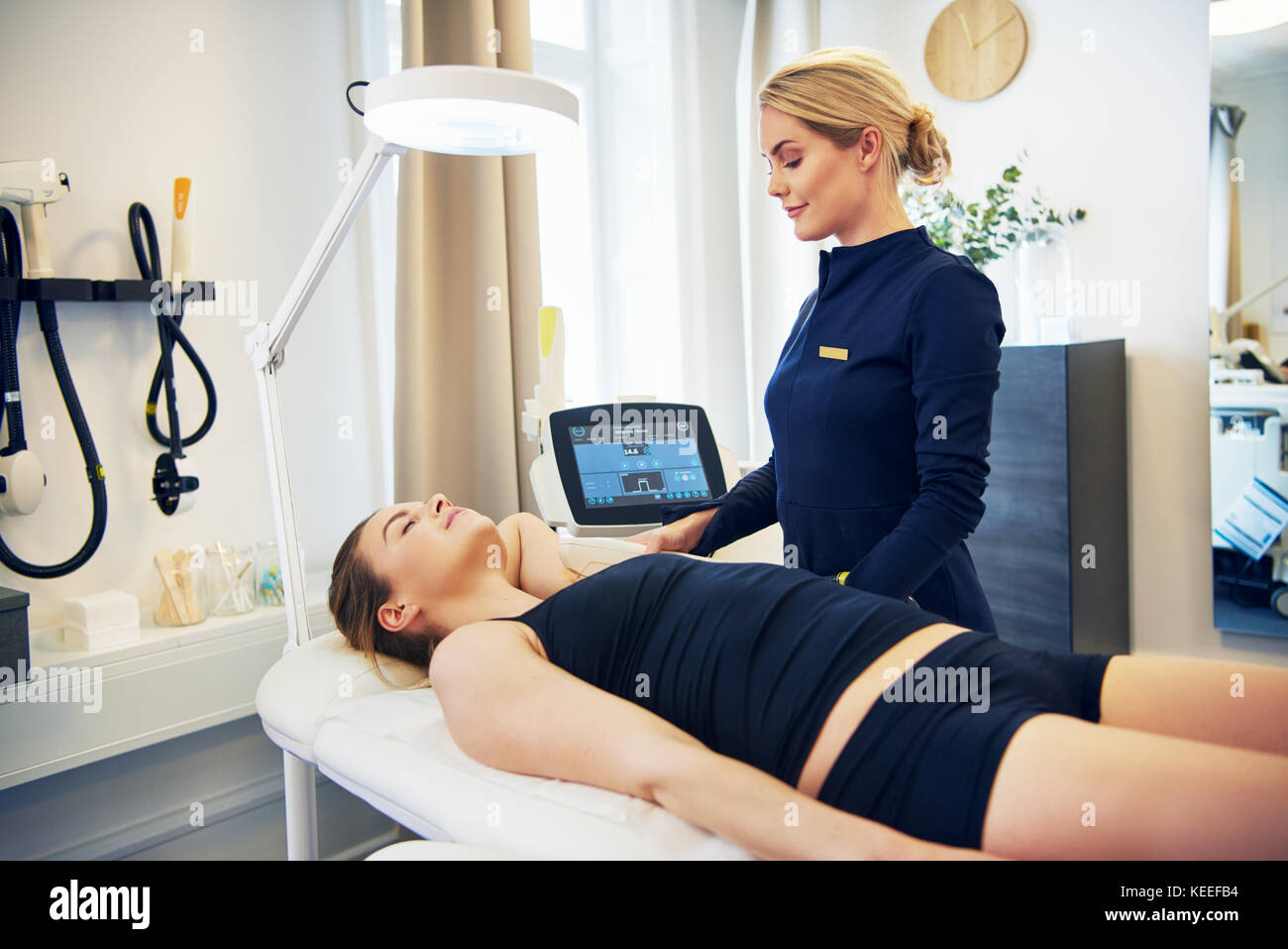 Young female beautician doing an electrolysis hair removal procedure on the  underarm of a woman lying on a table in a beauty clinic Stock Photo - Alamy