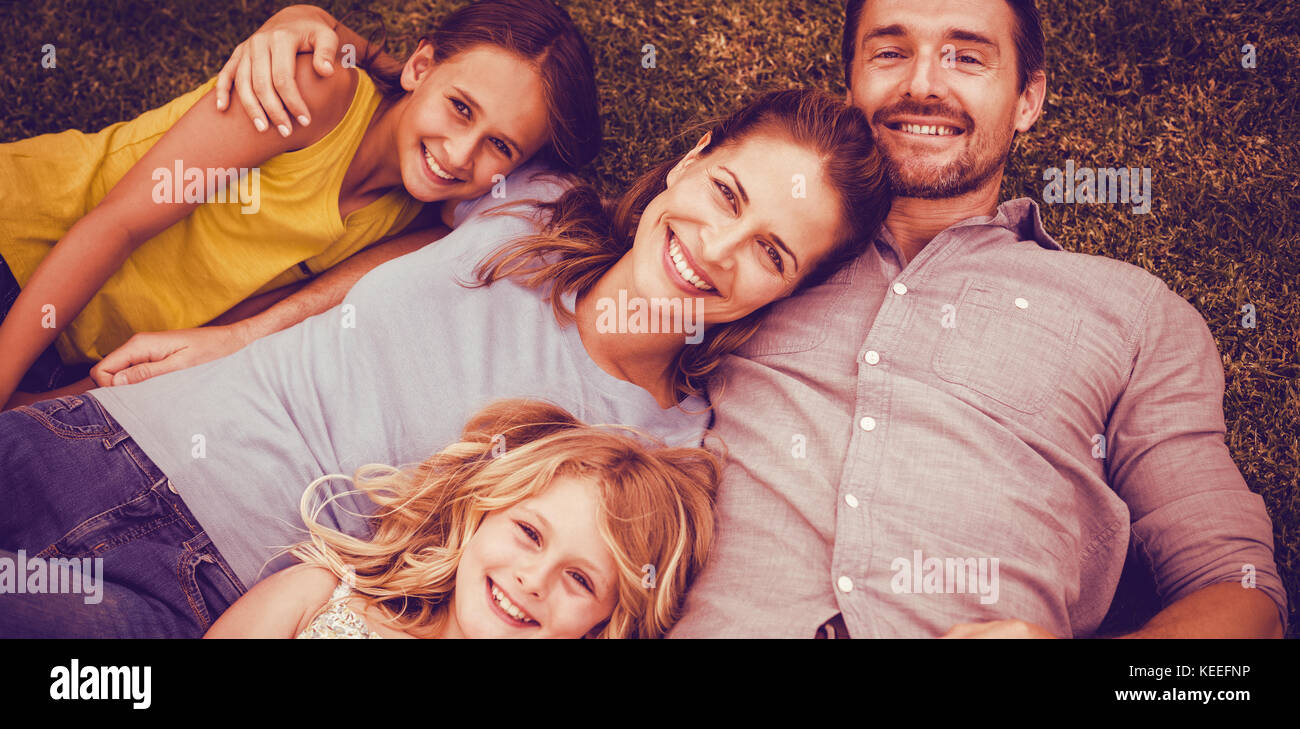 Portrait of happy family lying on field in back yard Stock Photo - Alamy