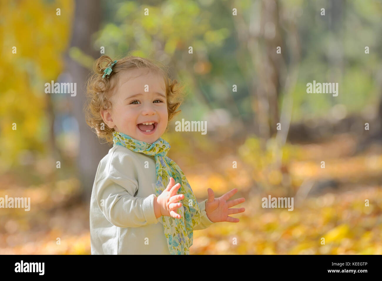 Happy little girl in autumn park Stock Photo - Alamy