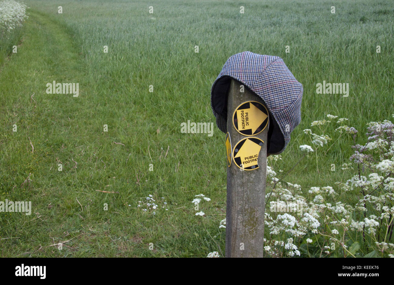 A lost flat cap on a post indicating footpaths Stock Photo