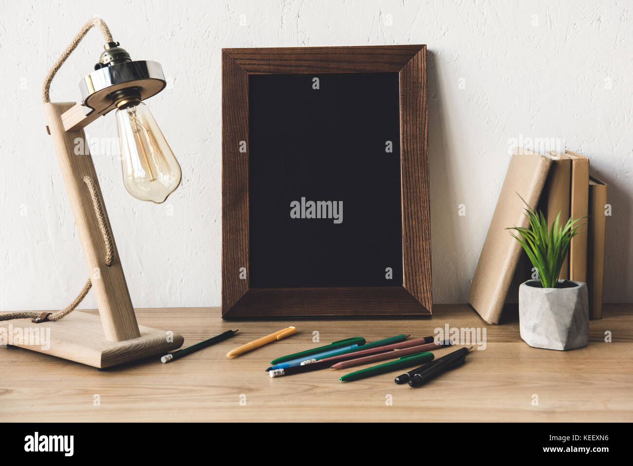 close up view of empty photo frame, table lamp and office supplies on