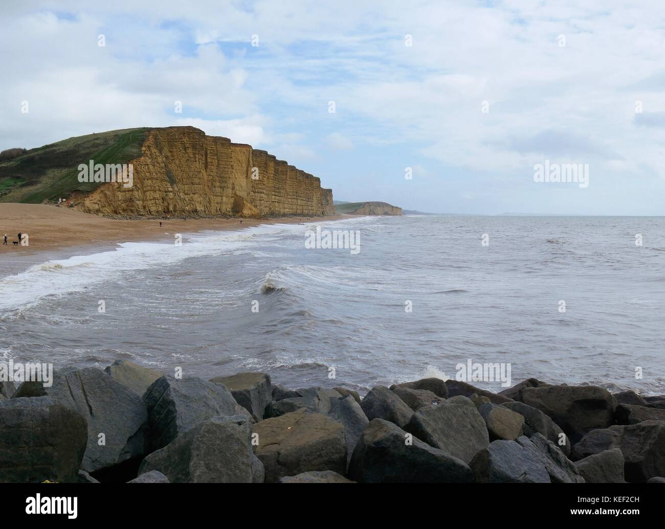 West Bay, Dorset, UK. 20th Oct 2017. UK Weather. People enjoying the relative calm before the storm predicted to hit the UK later today on a sunny but blustery day at the beach. Credit: Dan Tucker/Alamy Live News Stock Photo