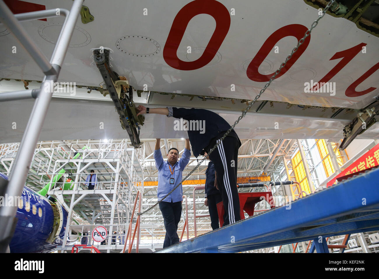 Shanghai, China. 18th Oct, 2017. System installation of the C919 aircraft coded 102 is underway at the assembly line of Shanghai Aircraft Manufacturing Co., Ltd. of the Commercial Aircraft Corporation of China (COMAC) in Shanghai, east China, Oct. 18, 2017. Staff workers completed paint spraying for the jet on Oct. 11. Larger C919 jet is a narrow-body jumbo designed to rival the updated Airbus A320 and the new Boeing B737. Credit: Ding Ting/Xinhua/Alamy Live News Stock Photo
