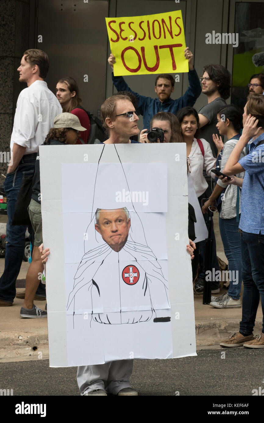 Austin, USA. 20th Oct, 2017. Protesters rally against U.S. Attorney General Jeff Sessions outside a downtown Austin, Texas office building where Sessions spoke to U.S. attorneys about the Trump administration's immigration policy. This protester's sign depicts Sessions wearing the white robe and hood associated with the White supremacist Ku Klux Klan (KKK) organization Credit: Bob Daemmrich/Alamy Live News Stock Photo