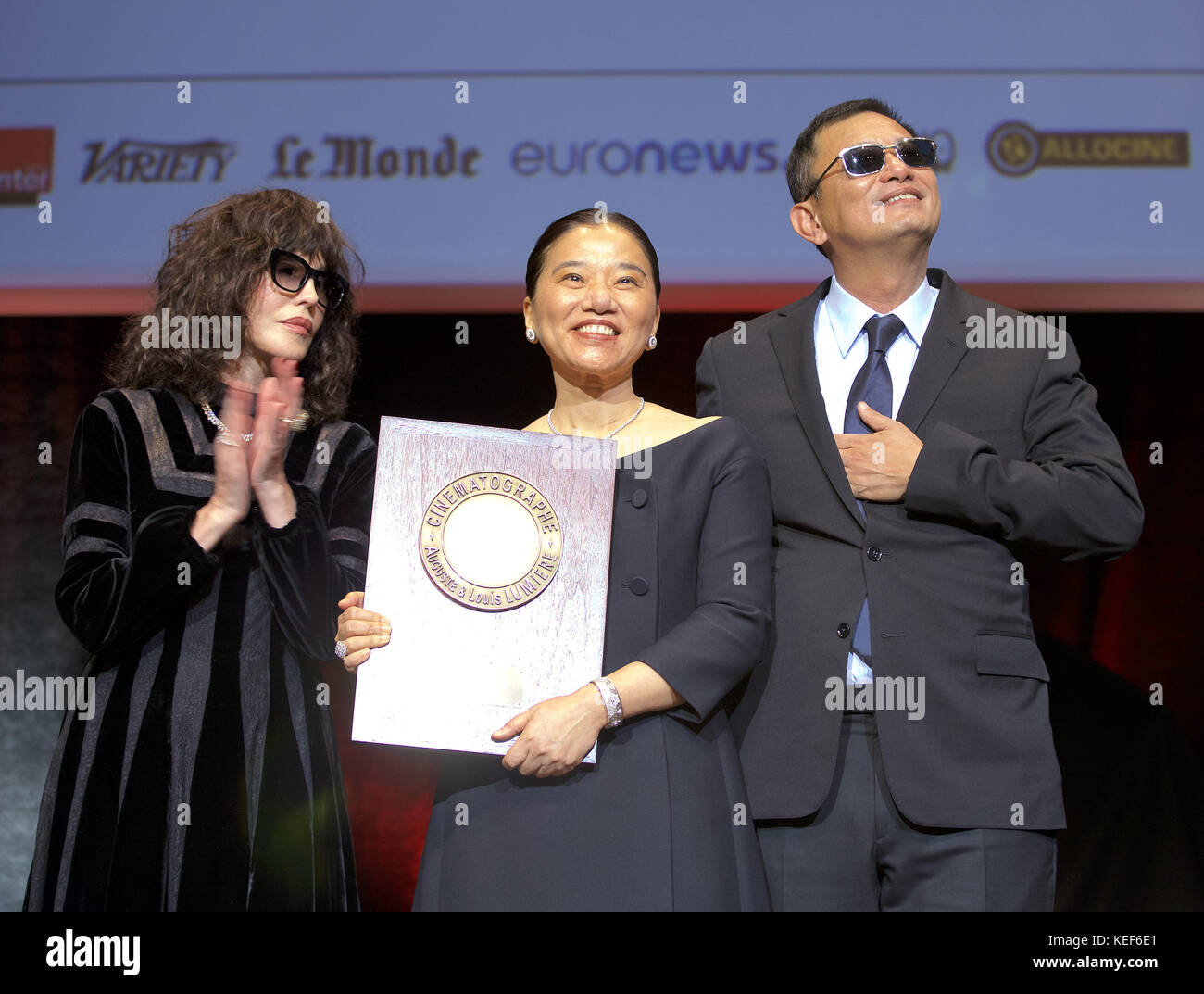 Lyon, France. 19th Oct, 2017. French actress Isabelle Adjani (left)helps present the Prix Lumiere 2017 to Chinese director Wong Kar-wai (right). The presentation marks the high point of the 9th annual Festival Lumiere, a film festival devoted to classic films. With them is Wong Kar-wei's wife and collaborator Esther. Credit: James Colburn/ZUMA Wire/Alamy Live News Stock Photo