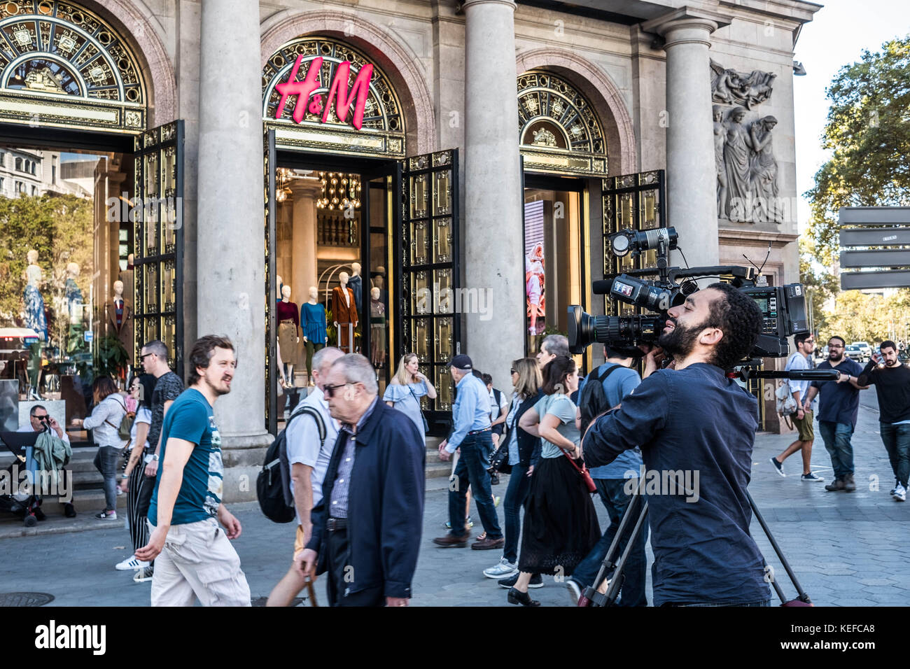 October 21, 2017 - Barcelona, Catalonia, Spain - A television cameraman performs close-ups over Paseo de Gracia street..While the Spanish President Mariano Rajoy told at a press conference the new powers to suspend the autonomy of the Catalan authority, Barcelona prepares in the great shopping Avenue of Passeig de Gracia a new concentration of the Catalan independence movement to demand the freedom of the two political prisoners Jordi Cuixart and Jordi AlvÃ rez. Throughout the morning national and international television and media have been deploying its equipment front of the indifferent eye Stock Photo