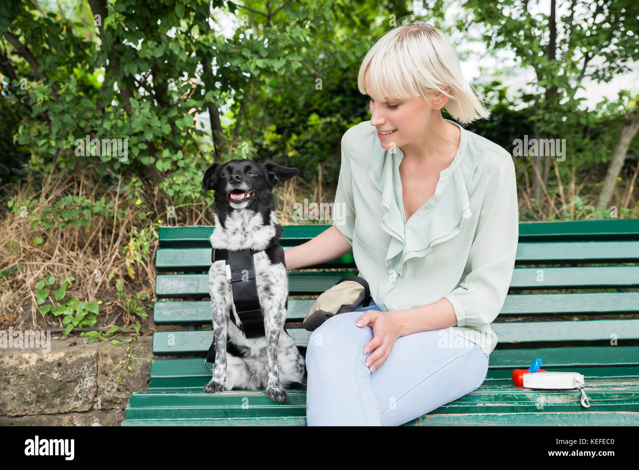 Lady sitting on bench with dog hi-res stock photography and images - Alamy