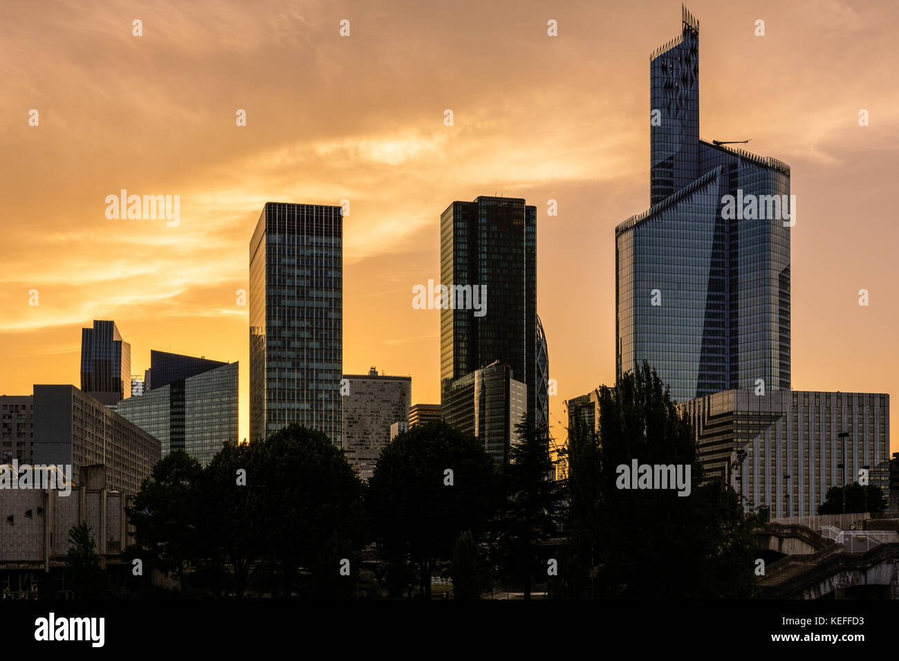 Paris La Defense business district skyline standing out against a glowing red sky at sunset. Stock Photo