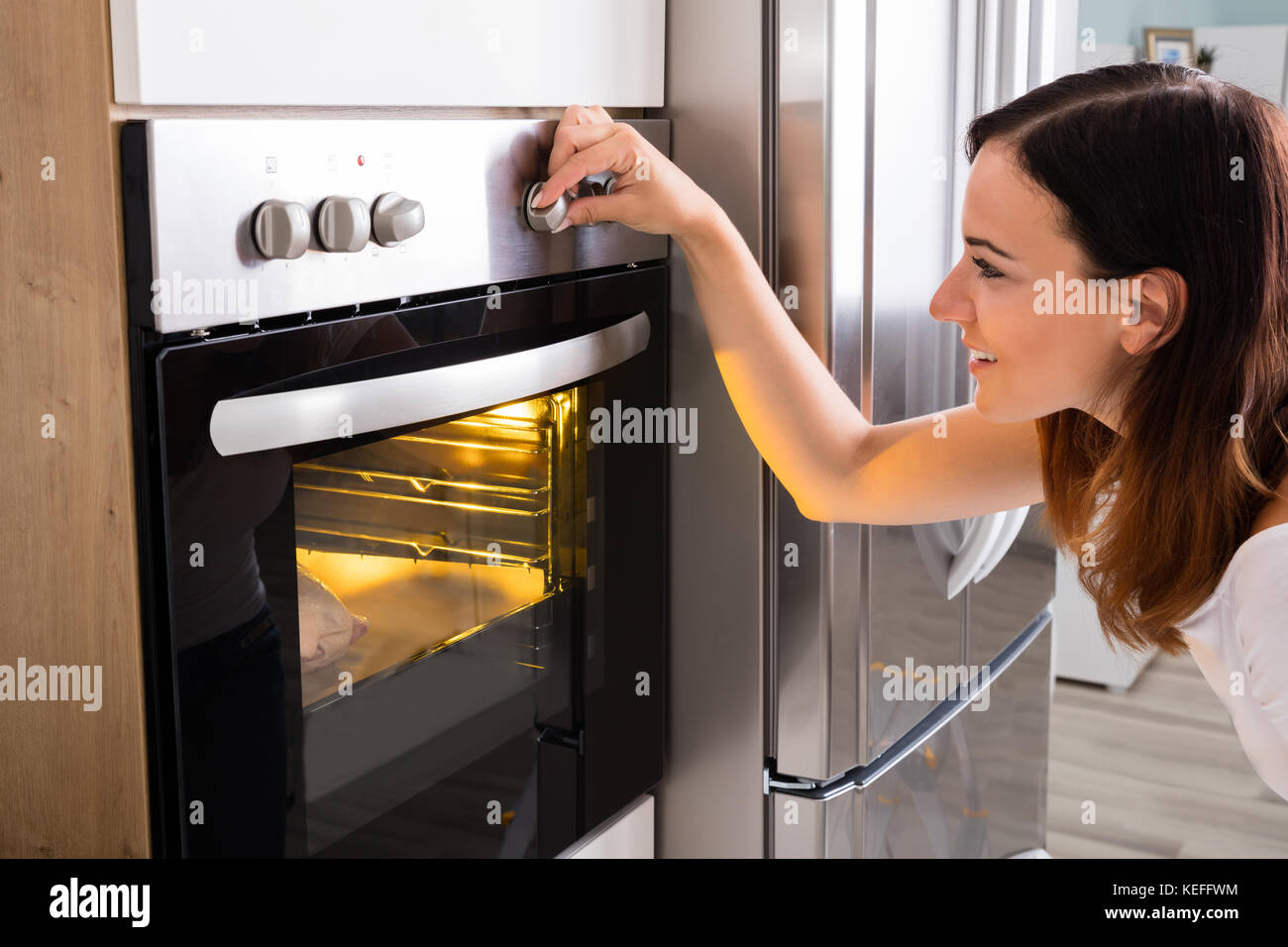 Young Happy Woman Roasting Chicken Meat In Kitchen Oven Stock Photo Alamy