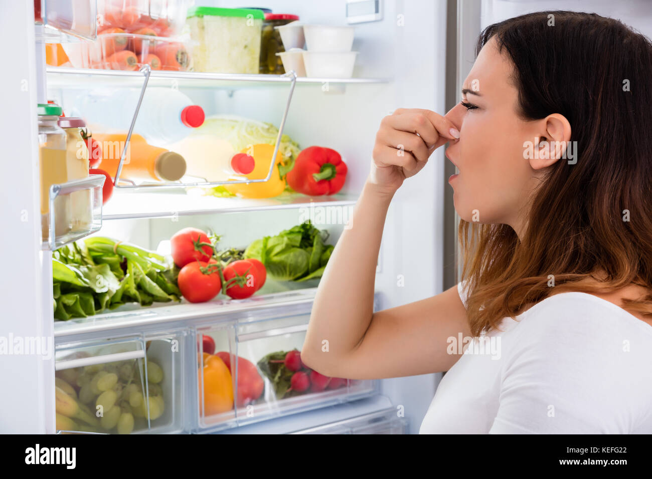 Young Woman Noticed Smell Coming Out Of Refrigerator Stock Photo