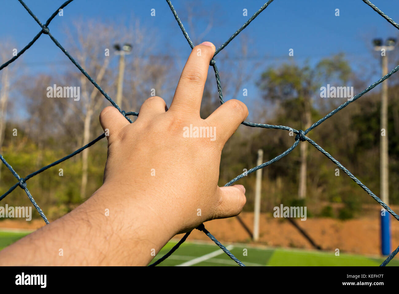 Hand grab the rope mesh fence Stock Photo Alamy
