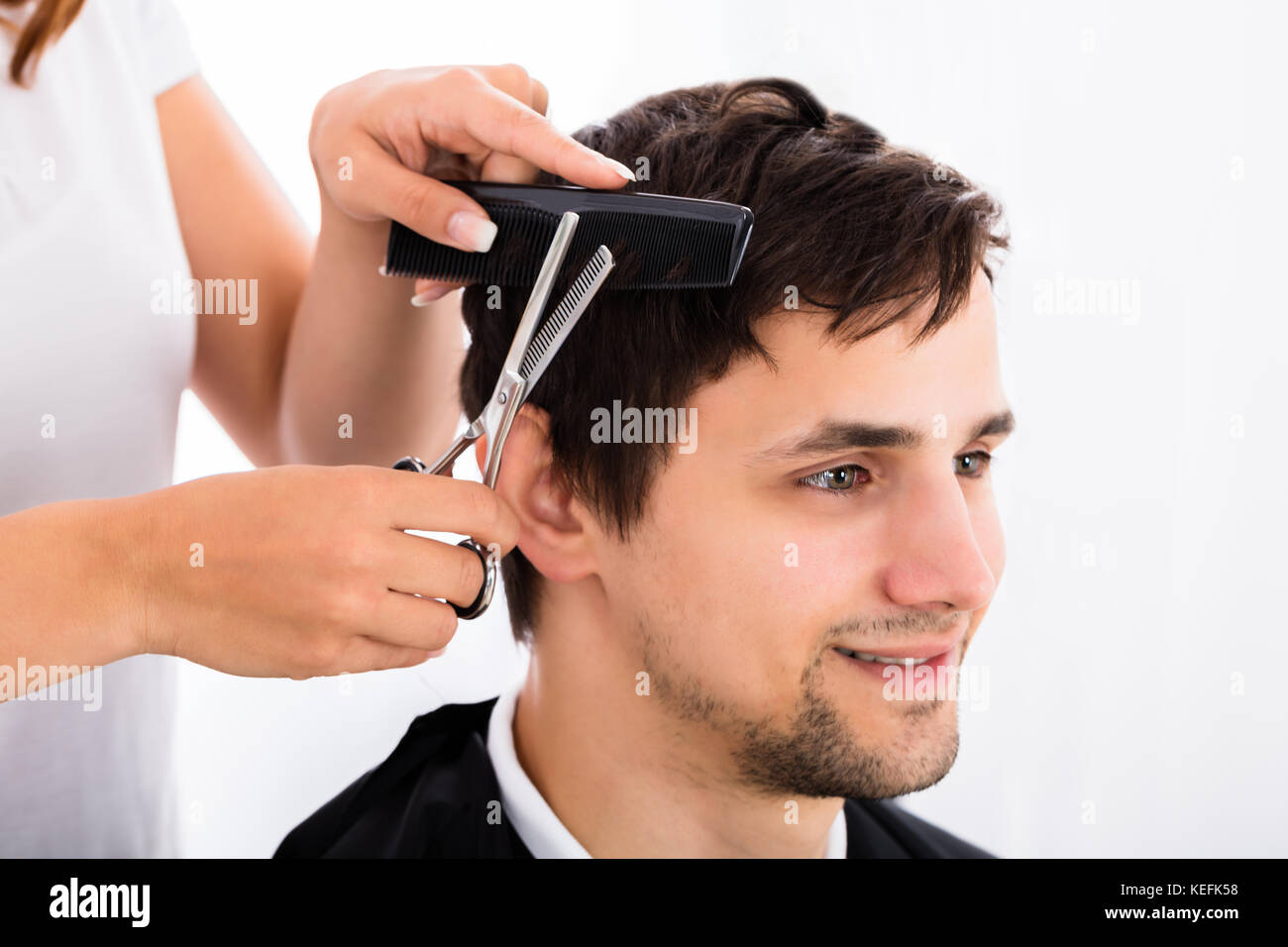 Happy Young Man Getting Haircut From Hairdresser Stock Photo