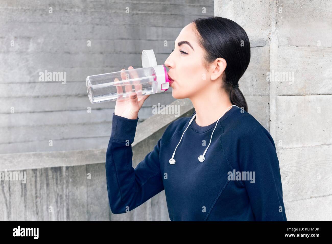 MODEL RELEASED. Young woman drinking water from bottle. Stock Photo