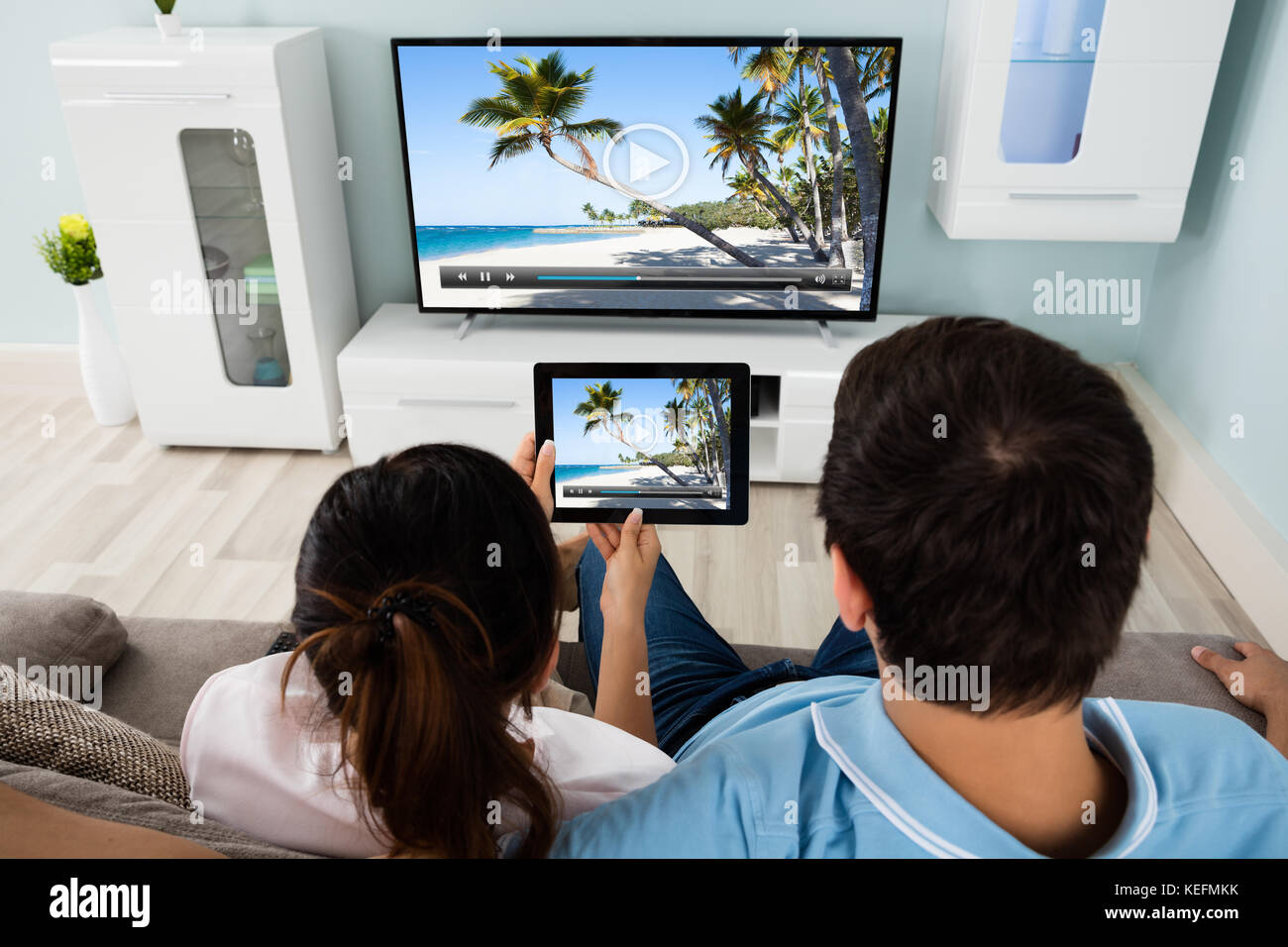 Young Couple Connecting Television Channel Through Wifi On Digital