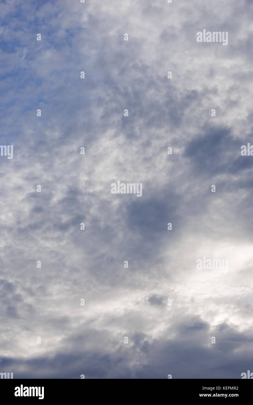Blue sky with dense white and grey cloud cover. Stock Photo