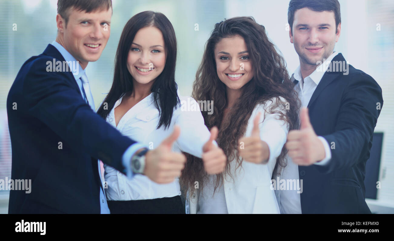Happy business team with thumbs up in the office Stock Photo - Alamy