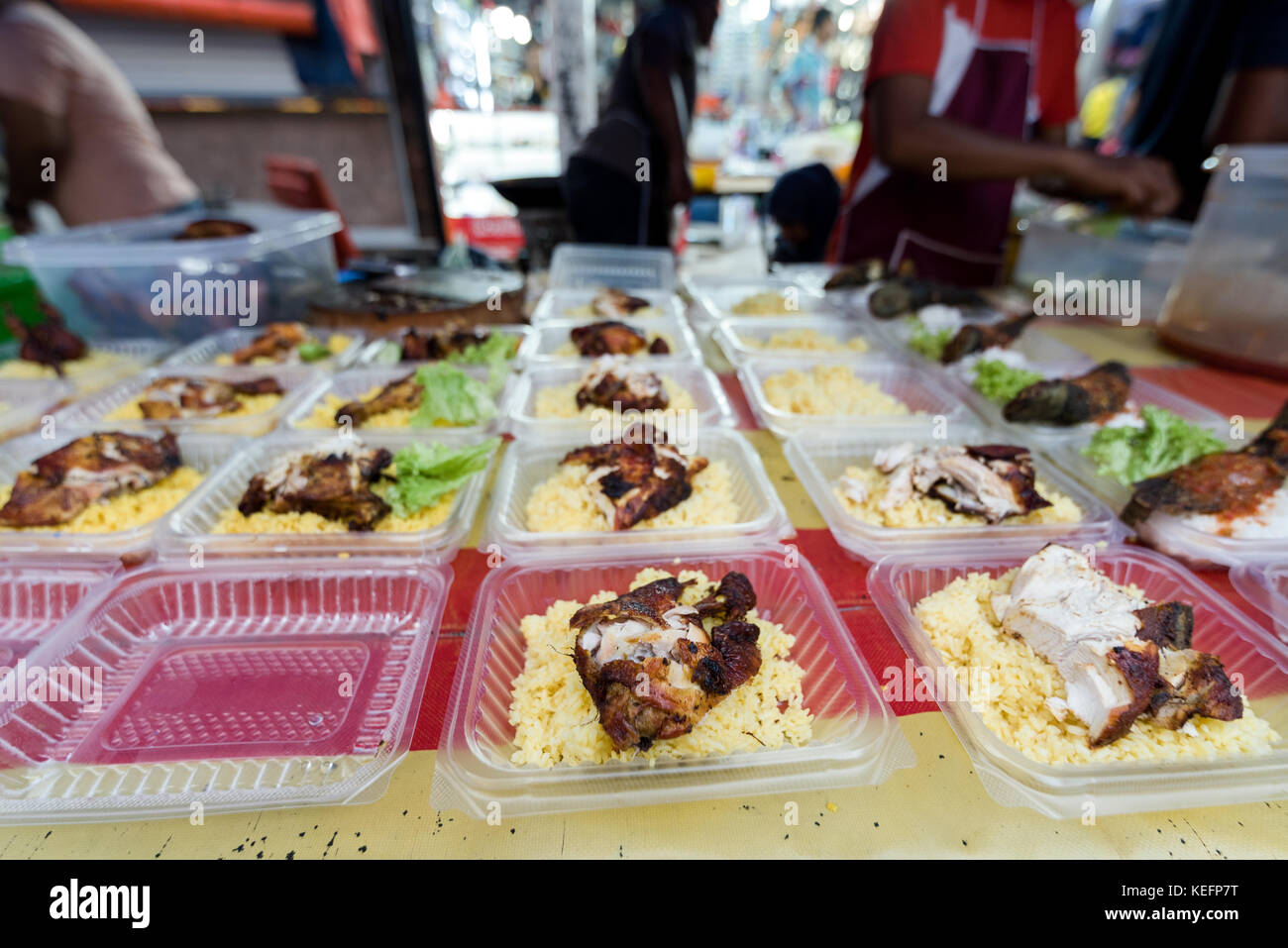 Many take away tubs of roasted chicken and rice waiting on a street food stall at a market in South east asia, Stock Photo