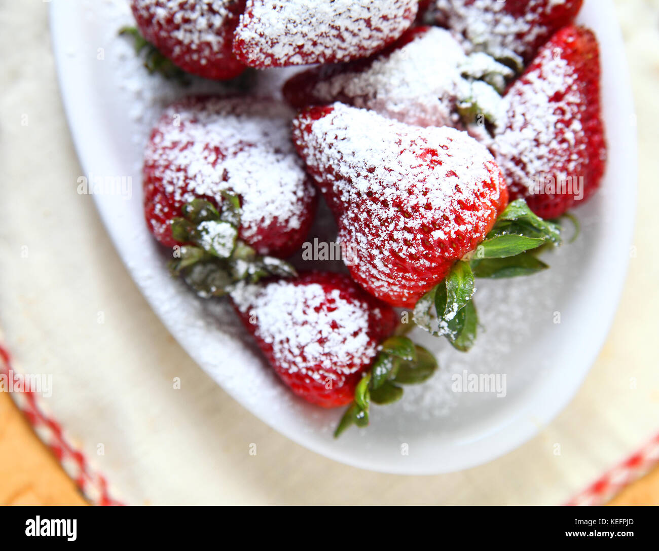 Fresh strawberries with powdered sugar in a white dish Stock Photo - Alamy