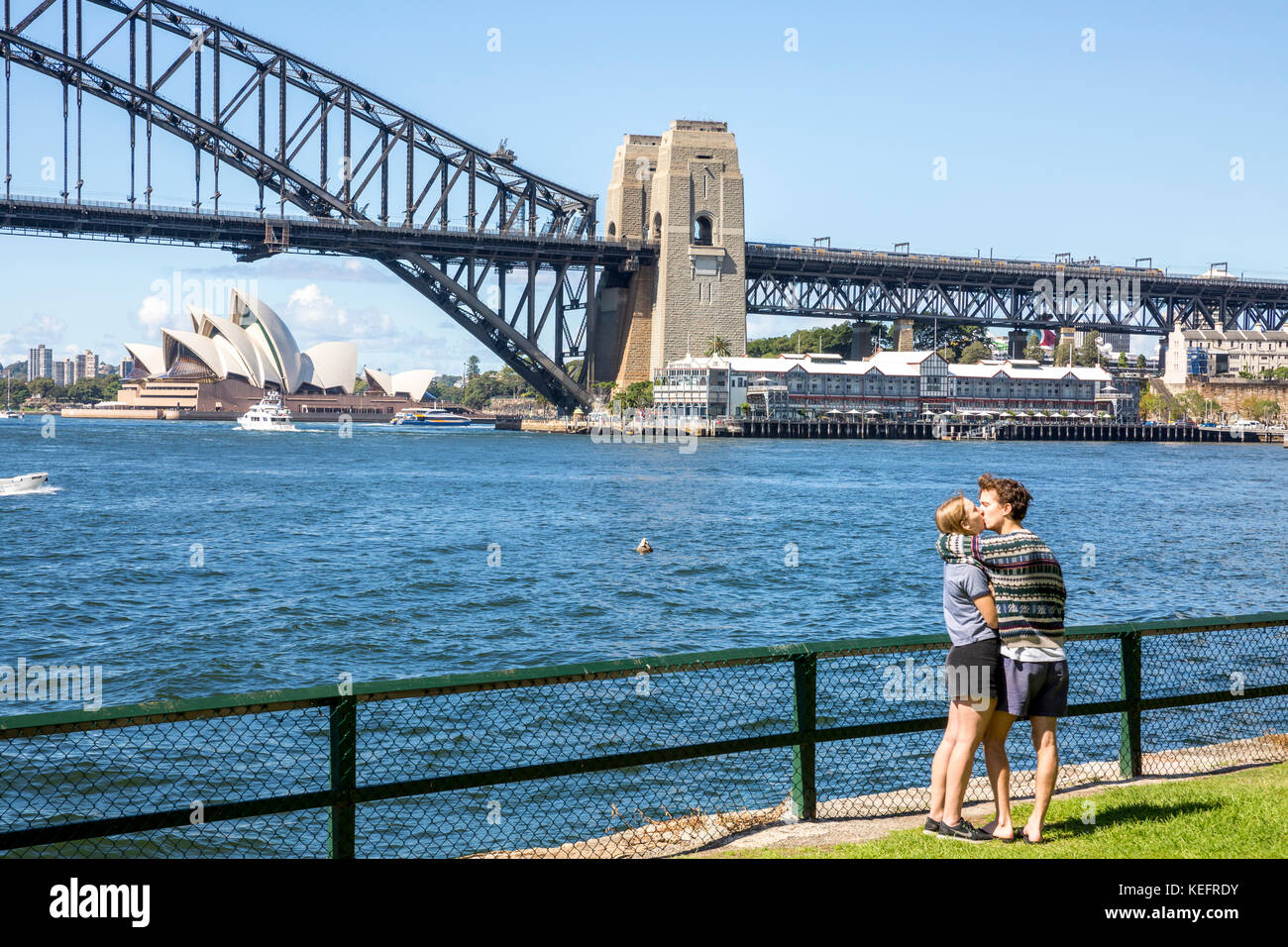 Male and female teenagers holding and kissing in Sydney with opera
