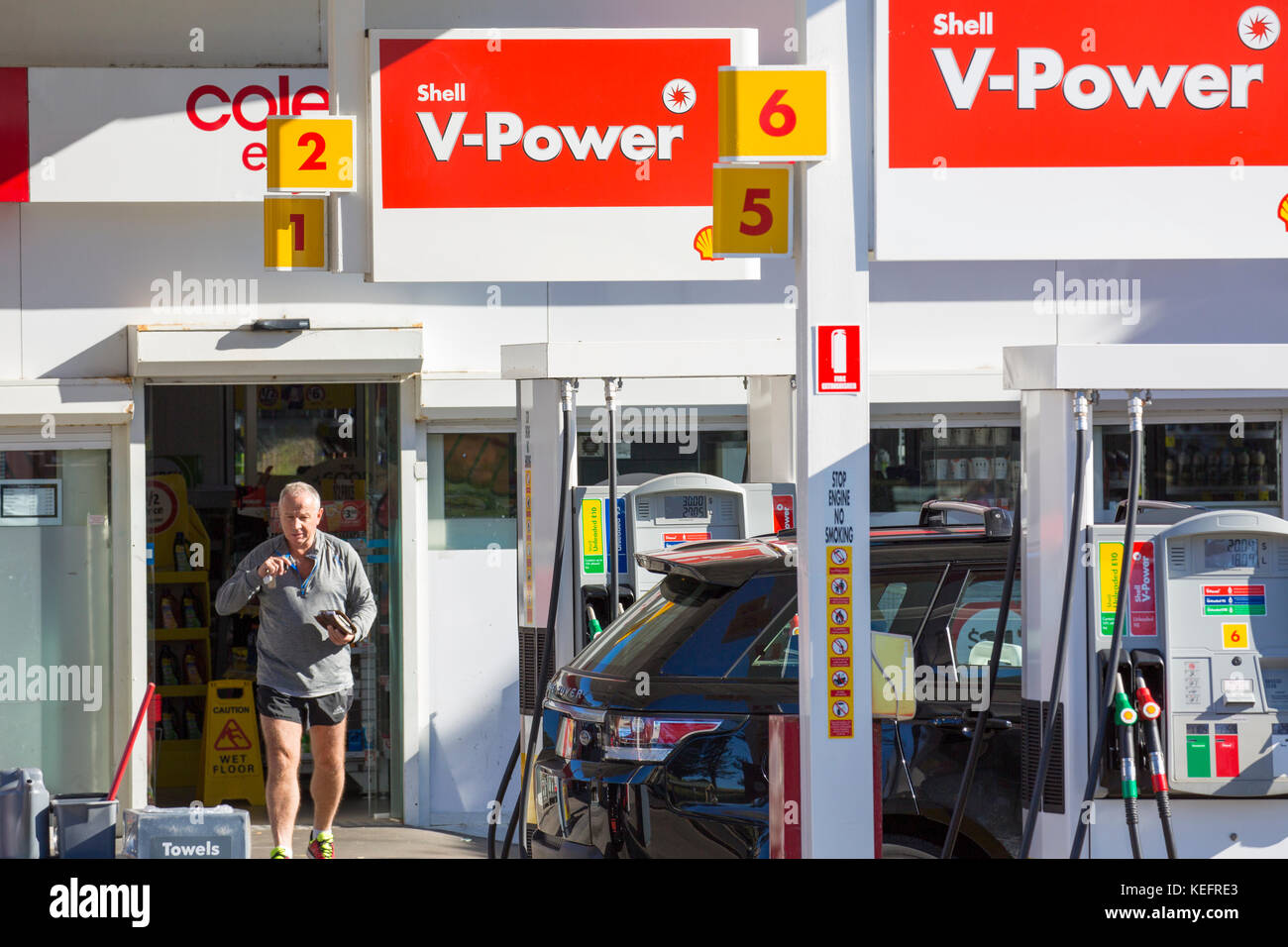 Adult man walks back to his car after filling up with fuel at a Shell service petrol station in Sydney,Australia Stock Photo
