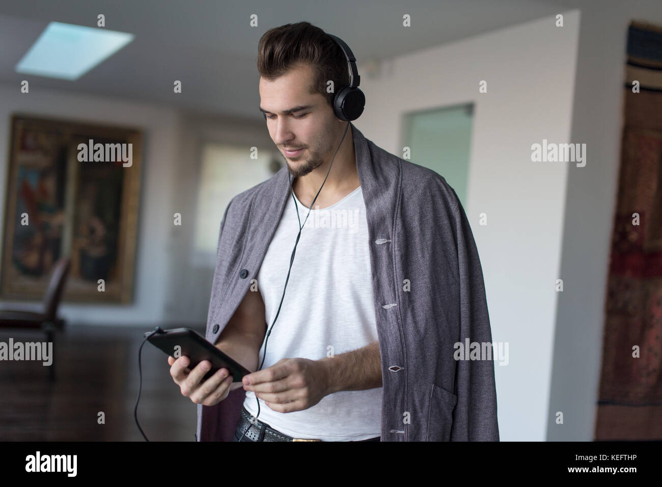 Casual caucasian man listening music on winter day indoor Stock Photo