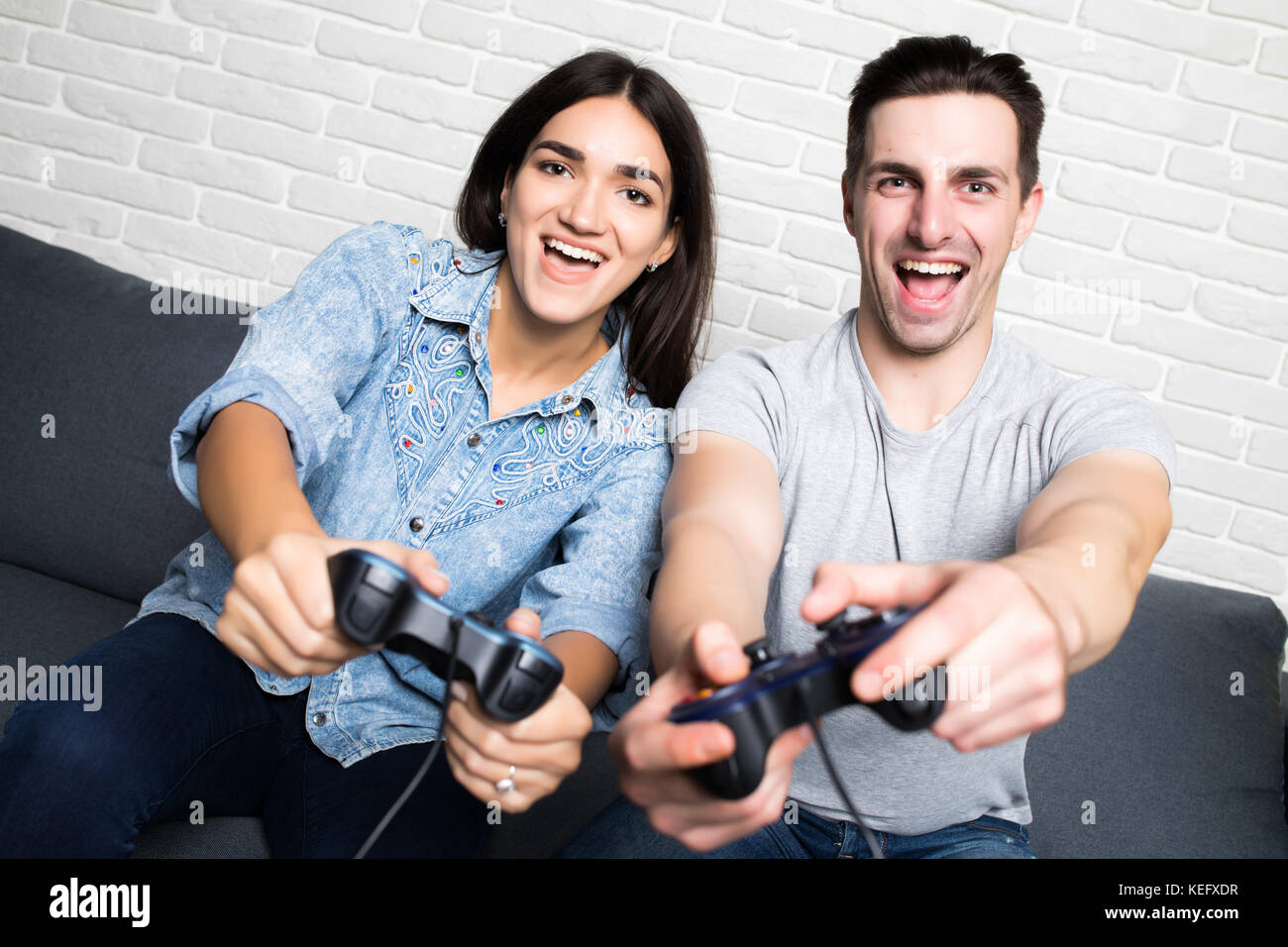 Teenage Couple With Headphone Play Game Online At Home Computer. Stock  Photo, Picture and Royalty Free Image. Image 172632258.
