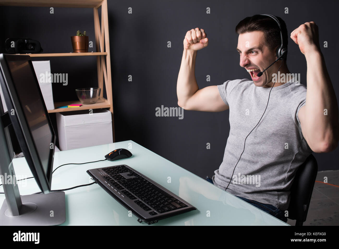 Happy Man Using Computer Euphoric winner happy man using a pc in a desk at home Stock Photo - Alamy
