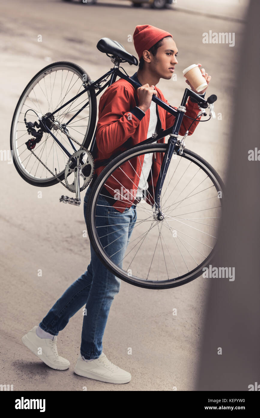 thoughtful man carrying vintage bicycle and drinking coffee to go Stock ...