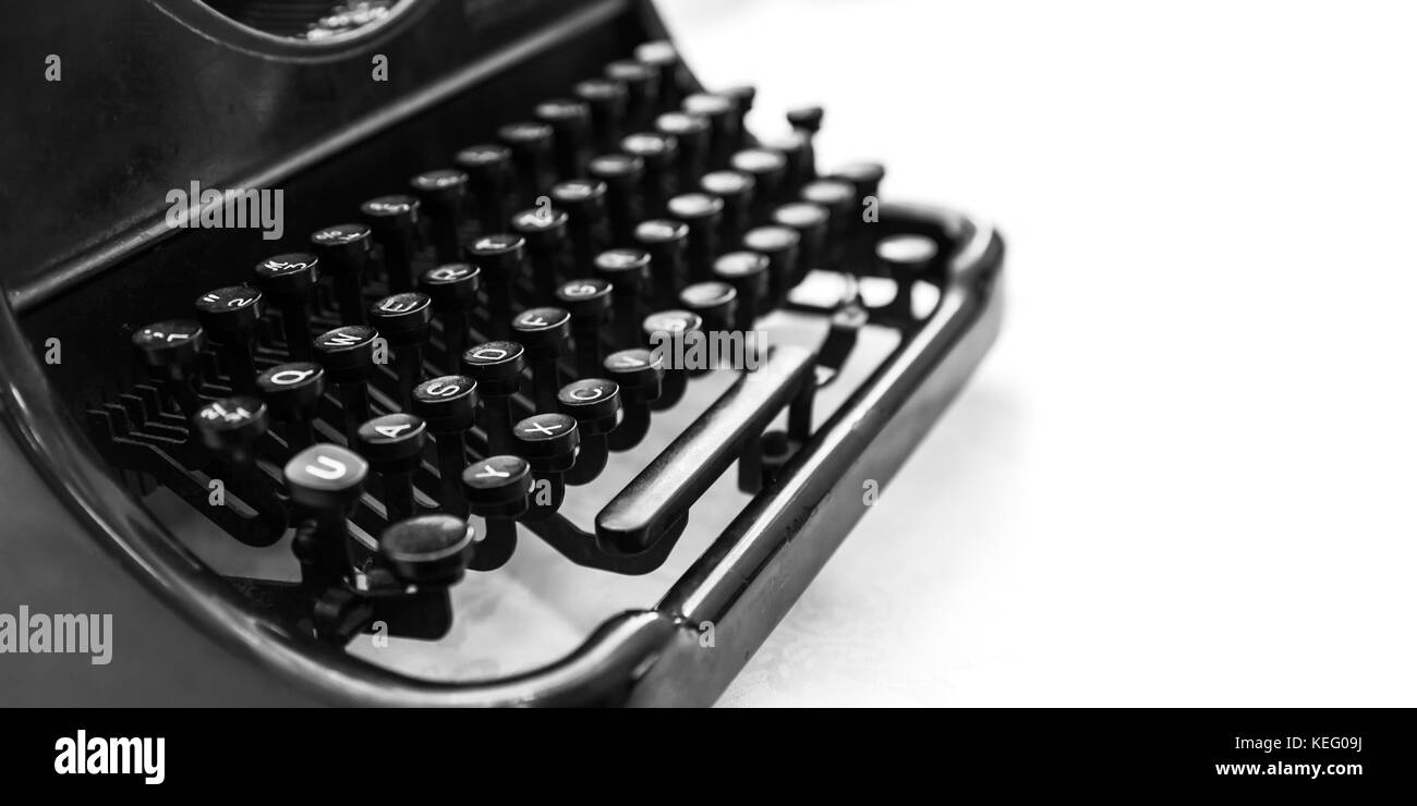 Old manual typewriter machine, closeup fragment with keyboard over white background, black and white photo with soft selective focus Stock Photo