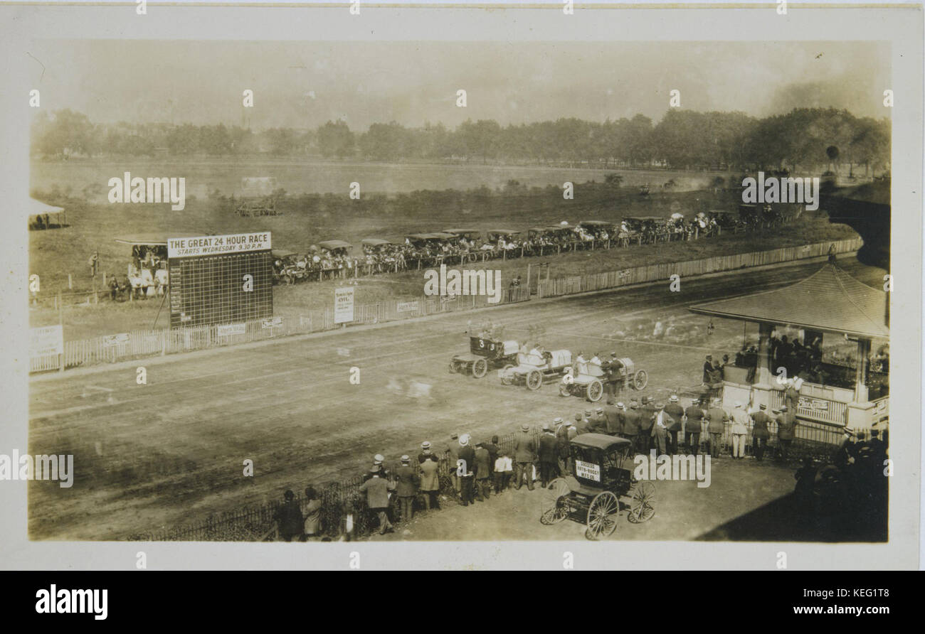 Spectators watching as automobiles line up to race during or shortly before  The Great 24 Hour Race  at the Fairgrounds Park auto racing track Stock Photo