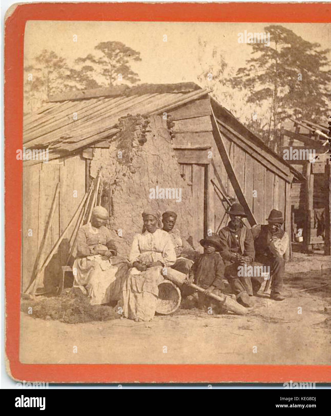 Family group sitting in front of a wooden shack, from Robert N. Dennis collection of stereoscopic views Stock Photo