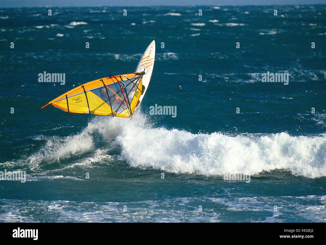 Sport. Man on sailboard wave hopping. Stock Photo