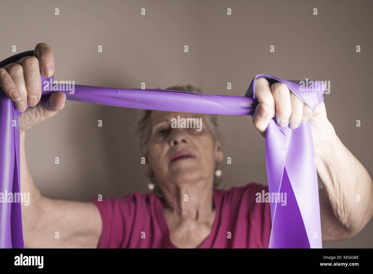 Rehabilitation exercises for older women with elastic band Stock Photo