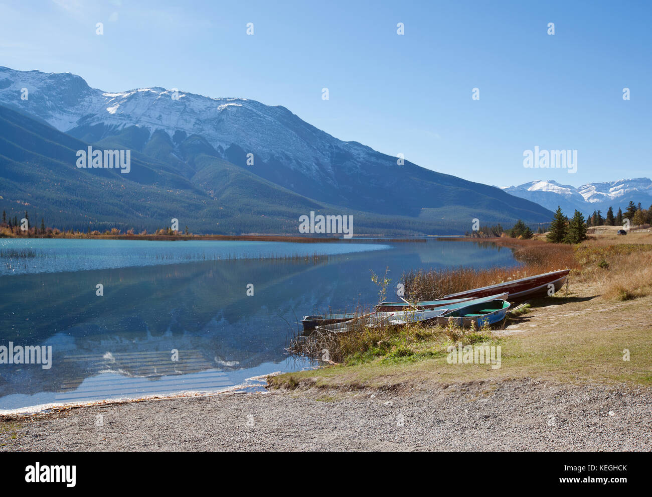 rowboats by the lakeside with gorgeous rocky mountain range behind in Canada Stock Photo