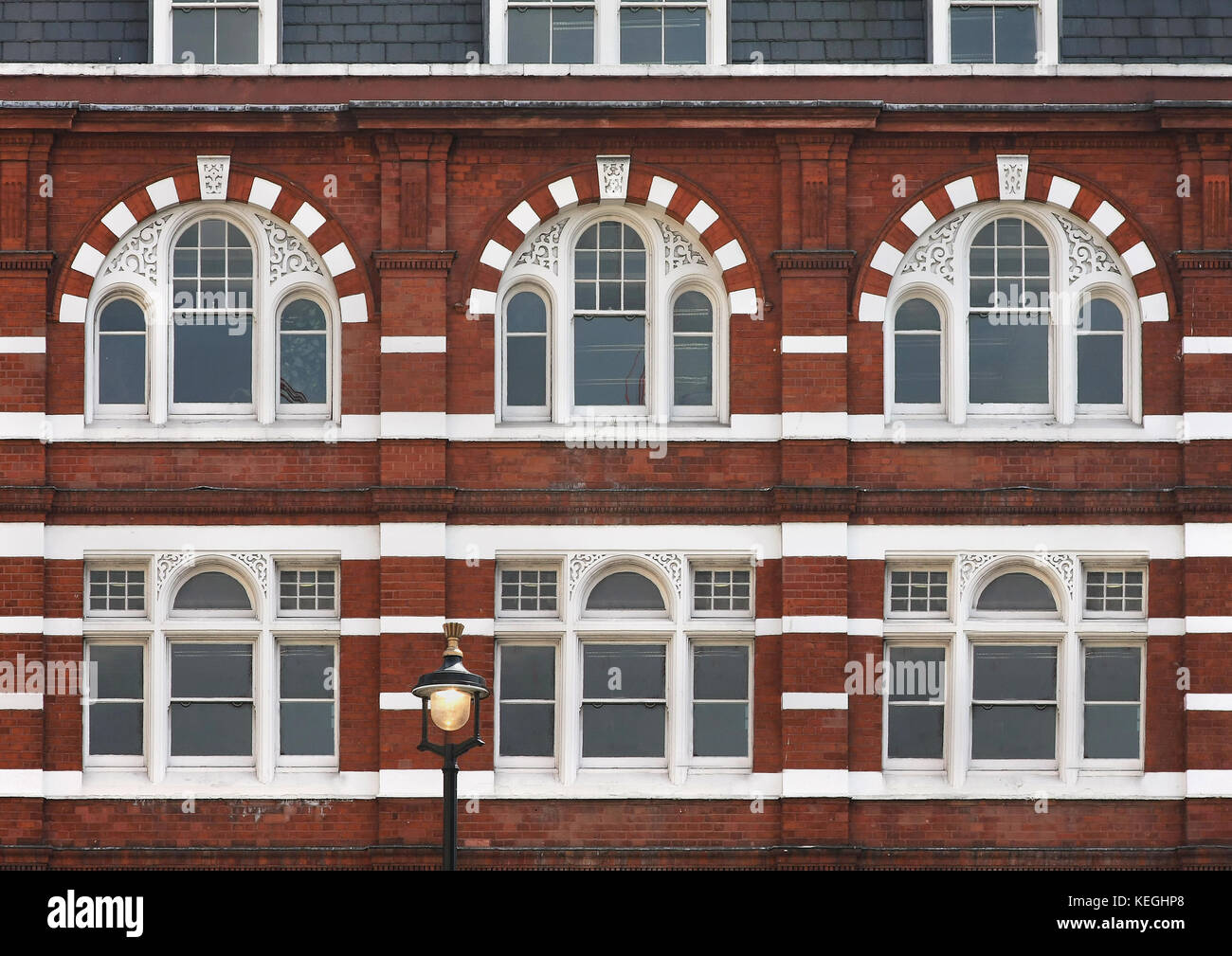 Building facade with arched windows and brick wall Stock Photo - Alamy