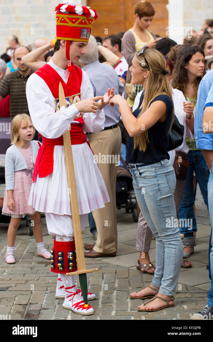 Male dancer in costume with woman in contemporary outfit at San Fermin Fiesta at Pamplona, Navarre, Northern Spain Stock Photo