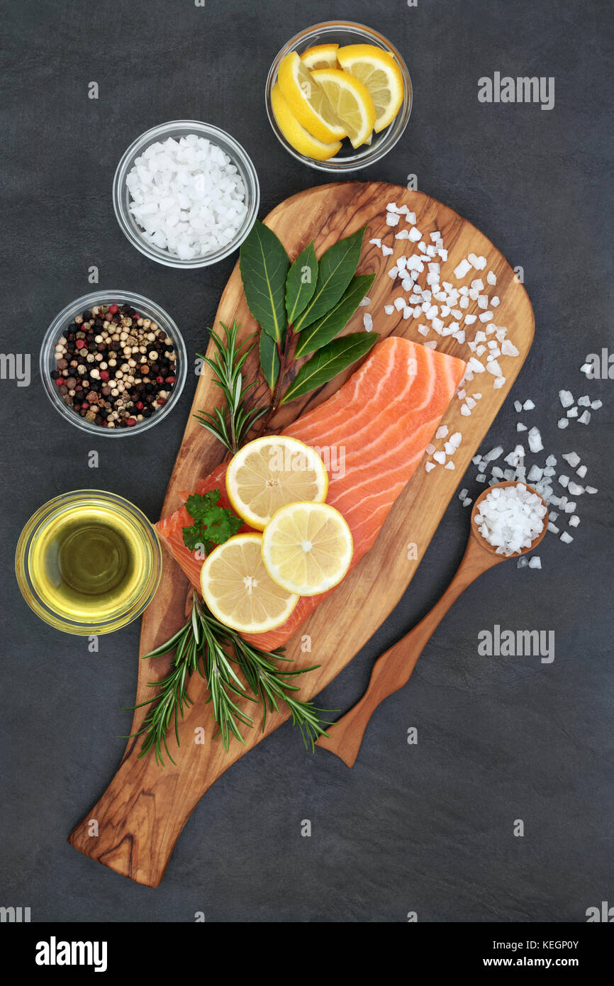 Fresh salmon fish with herbs, seasoning, olive oil and lemon fruit on