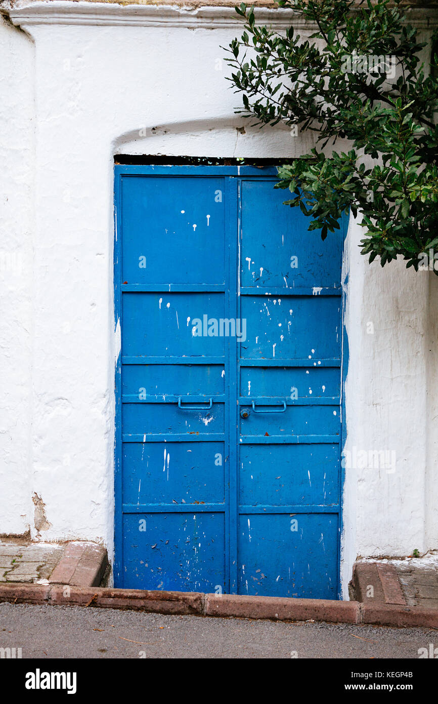 Blue door in white wall vertical selective focus Stock Photo