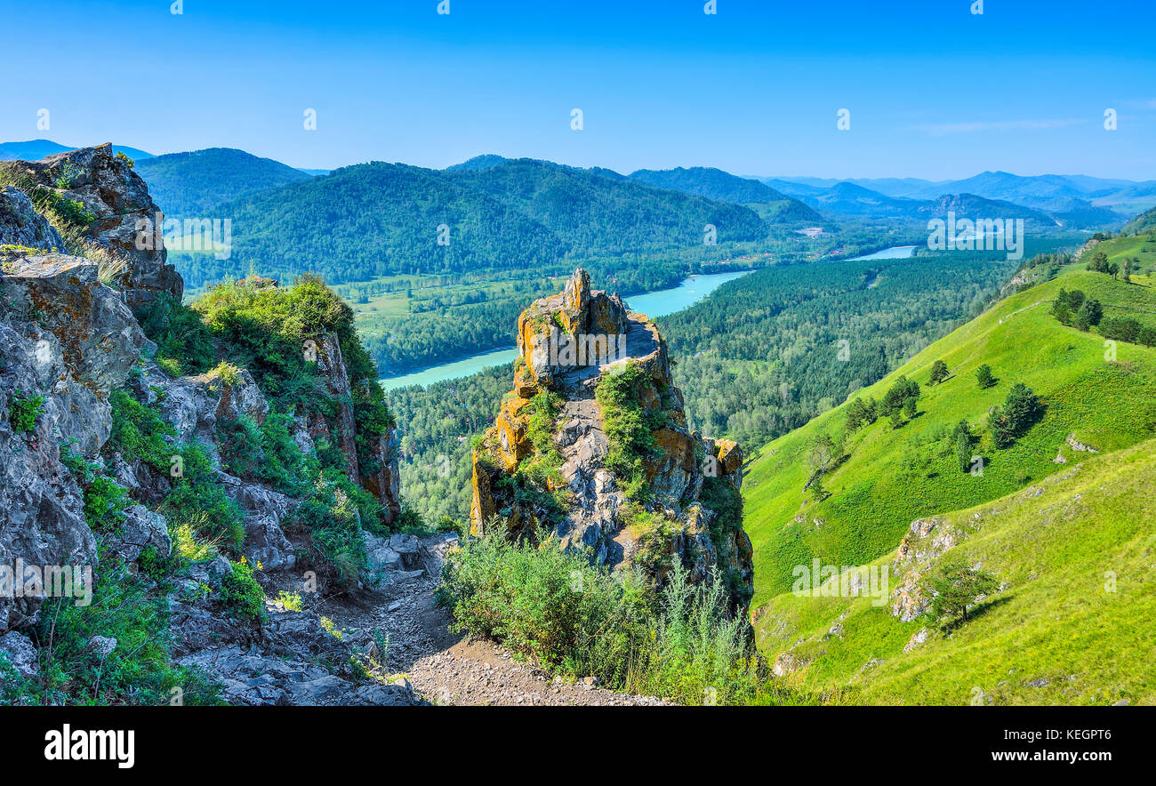Cliffs over the swift mountain turquoise river Katun, flowing in the valley among the banks with dense forests covered - beautiful sunny summer landsc Stock Photo