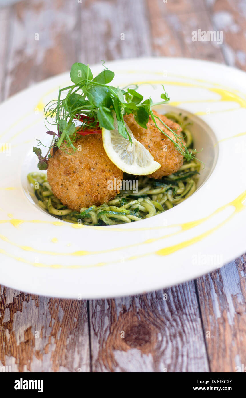 Crab cakes with pasta, courgette and watercress Stock Photo Alamy