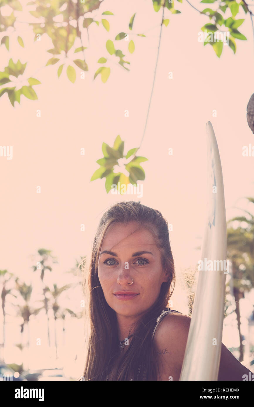 Portrait of Caucasian woman holding surfboard Stock Photo - Alamy