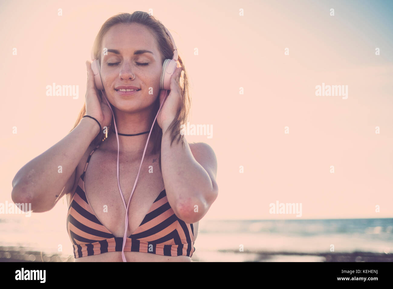 Caucasian woman listening to headphones on beach Stock Photo