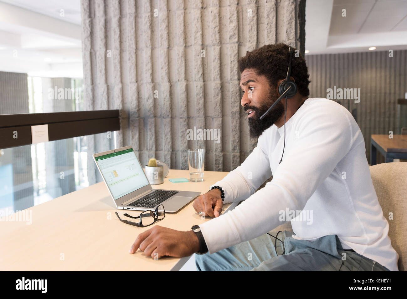 Black man wearing headset using laptop Stock Photo