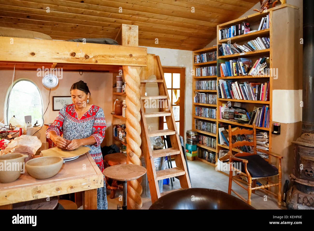 Mixed race woman shaping clay in art studio Stock Photo