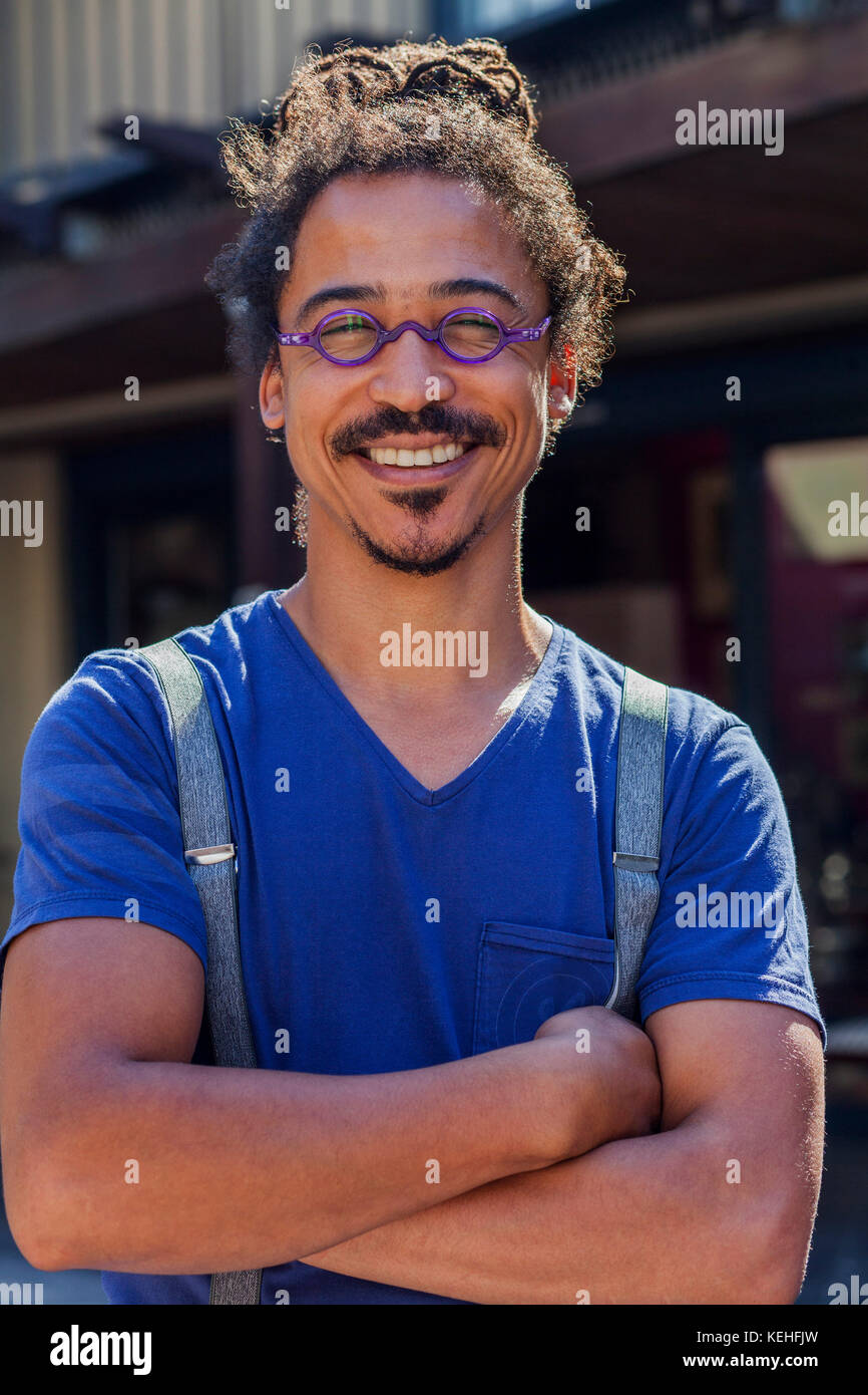 Smiling mixed race man wearing suspenders Stock Photo