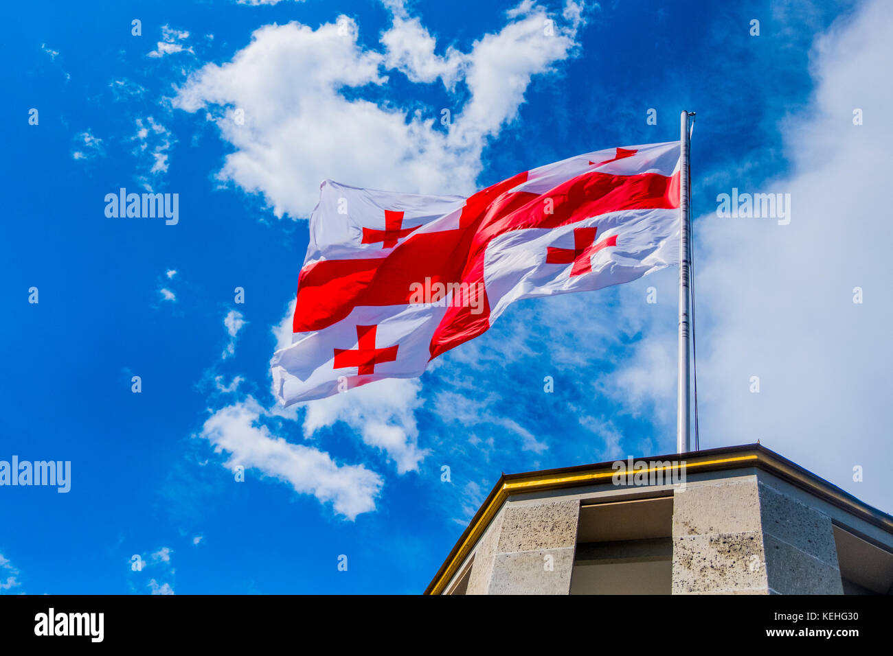Flag blowing in wind on top of building Stock Photo